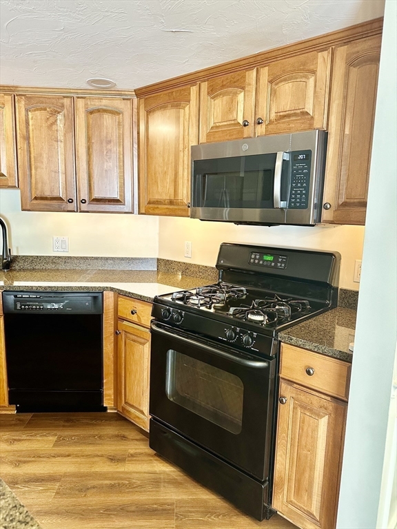 5 Mission Road, Unit 101 Chelmsford, MA 01863 - Photo 5 of 18 a kitchen with stove and cabinets