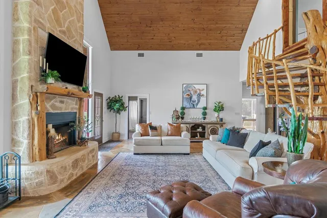 a living room with furniture a flat screen tv and a fireplace