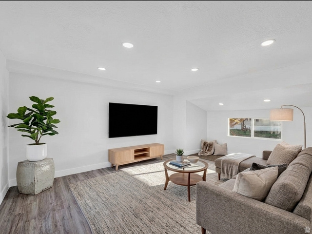 2491 Highway 89, Unit 523 Pleasant View, UT 84404 - Photo 4 of 31 Spacious living area featuring light wood-finish flooring, recessed lighting, white walls, and bright window openings. Virtual stage