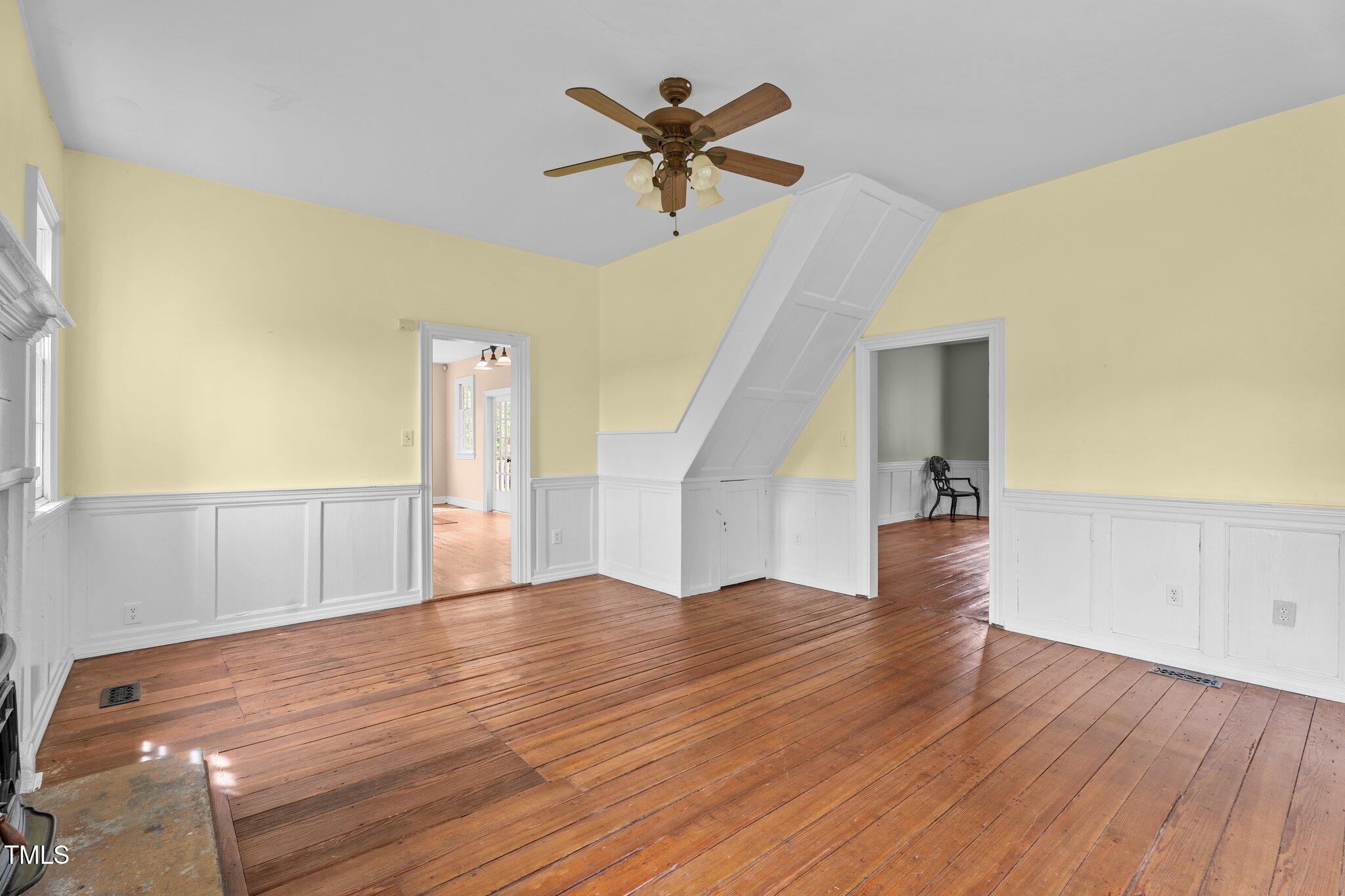 7404 Halifax Road Zebulon, NC 27597 - Photo 12 of 39 a view of an empty room with wooden floor and a ceiling fan