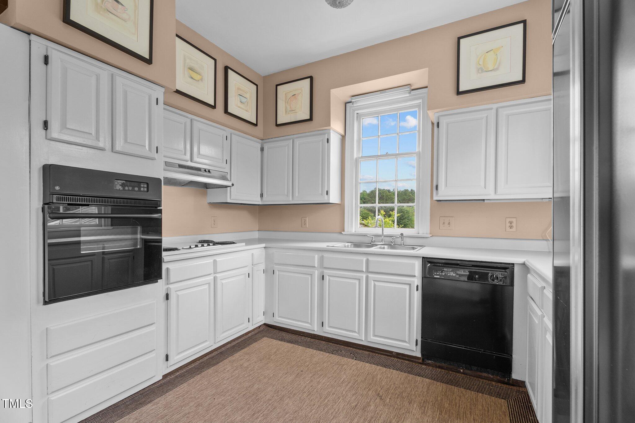 7404 Halifax Road Zebulon, NC 27597 - Photo 20 of 39 a kitchen with granite countertop white cabinets and white appliances