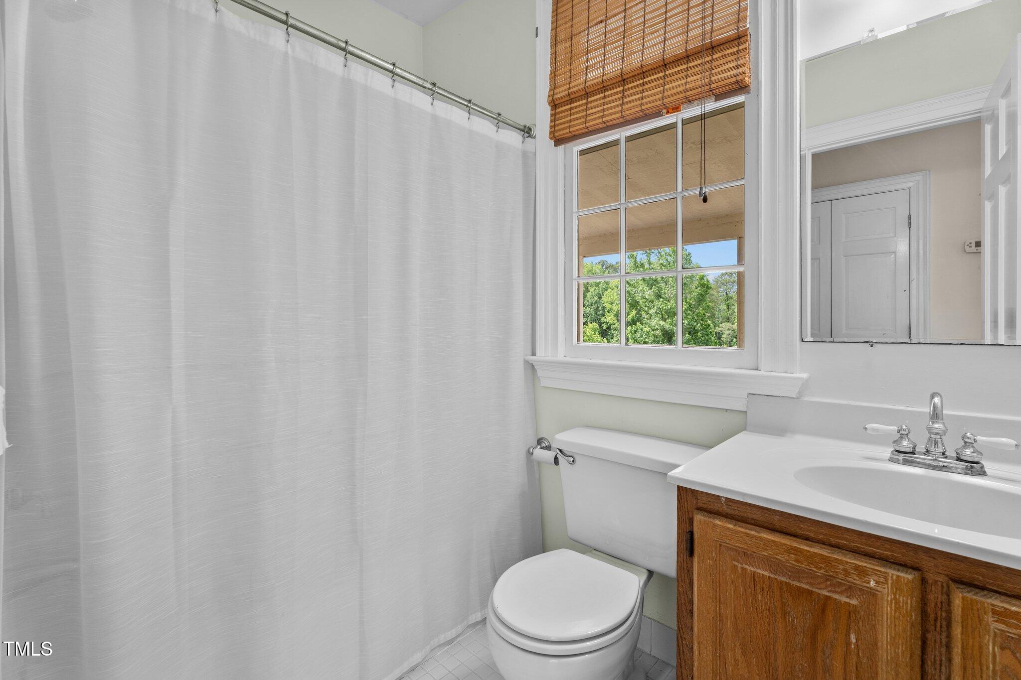 7404 Halifax Road Zebulon, NC 27597 - Photo 26 of 39 a bathroom with a toilet a sink and a window