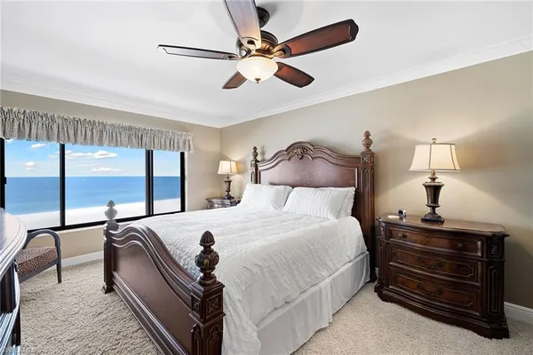 a bedroom with a bed a chandelier and large window