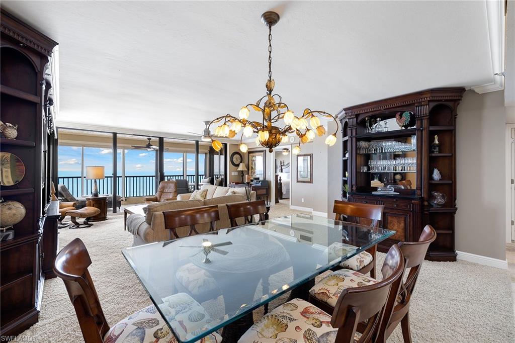 100 North Collier Boulevard, Unit 1201 Marco Island, FL 34145 - Photo 2 of 26 a living room with furniture a chandelier and a large window