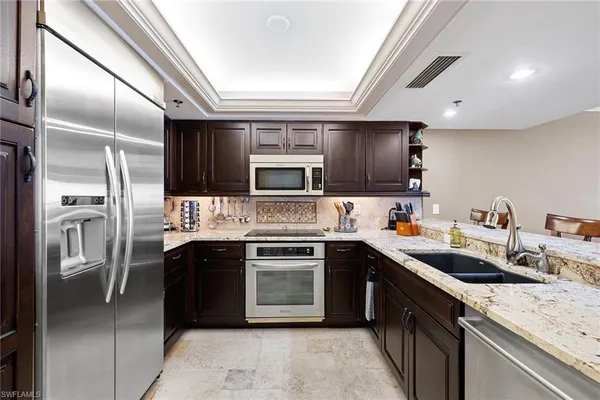 a kitchen with stainless steel appliances granite countertop a sink stove oven and refrigerator
