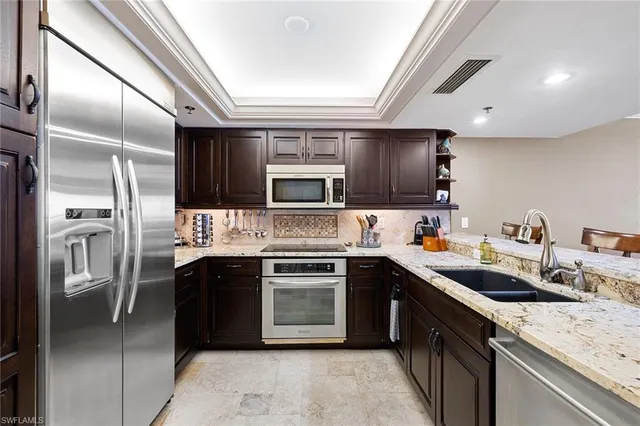 a kitchen with stainless steel appliances granite countertop a sink stove oven and refrigerator