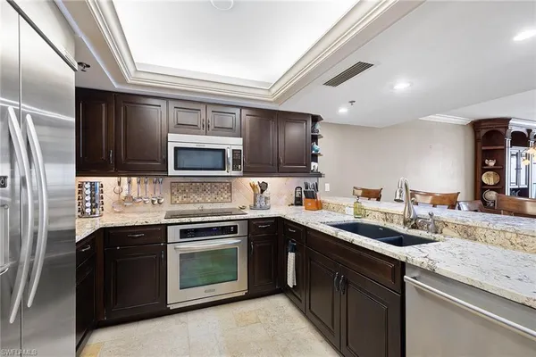 a kitchen with stainless steel appliances granite countertop a stove sink and refrigerator
