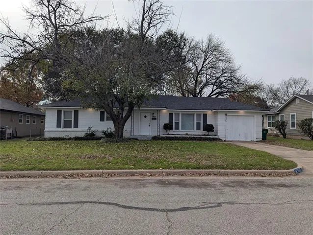 a front view of a house with a yard and a garage