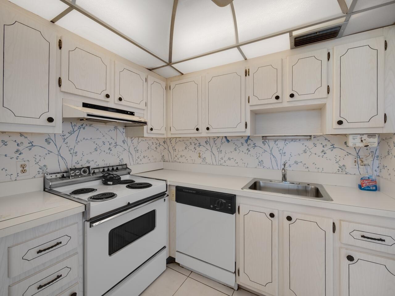 438 Monaco J Delray Beach, FL 33446 - Photo 15 of 15 a kitchen with white cabinets and white appliances