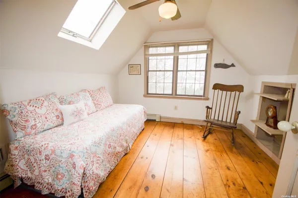 a bedroom with a bed a chair and a window