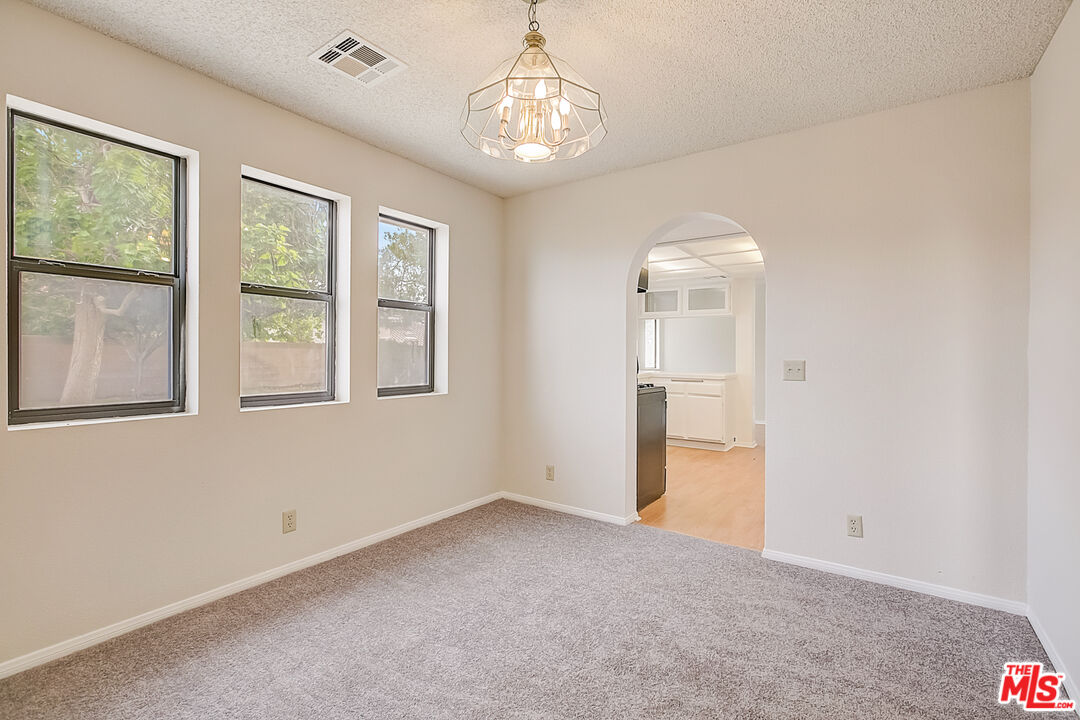 2535 West Ave K9 Lancaster, CA 93536 - Photo 15 of 35 an empty room with windows and chandelier