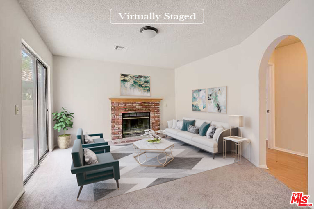 2535 West Ave K9 Lancaster, CA 93536 - Photo 2 of 35 a living room with furniture a fireplace and a potted plant