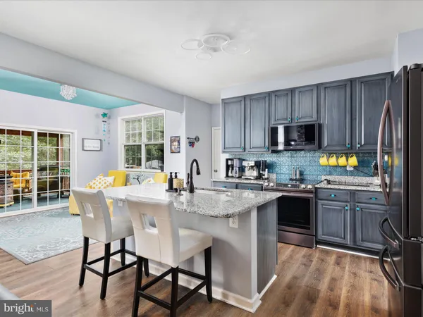 a kitchen with a table chairs microwave and cabinets