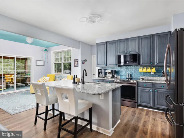 a kitchen with a table chairs microwave and cabinets