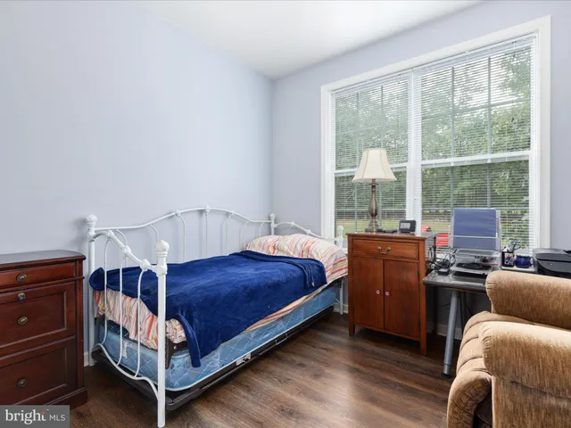 a bedroom with a bed and a larger window
