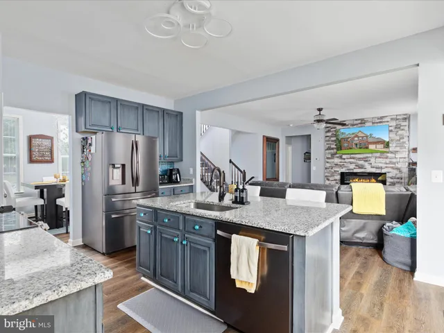 a kitchen with stainless steel appliances granite countertop a sink refrigerator and cabinets