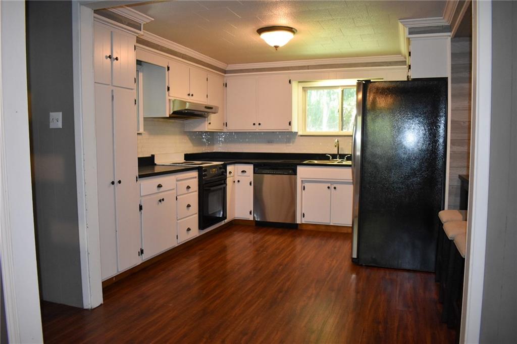 1039 Smithfield Road Smithfield, PA 15478 - Photo 3 of 16 a kitchen with granite countertop white cabinets a refrigerator and a sink