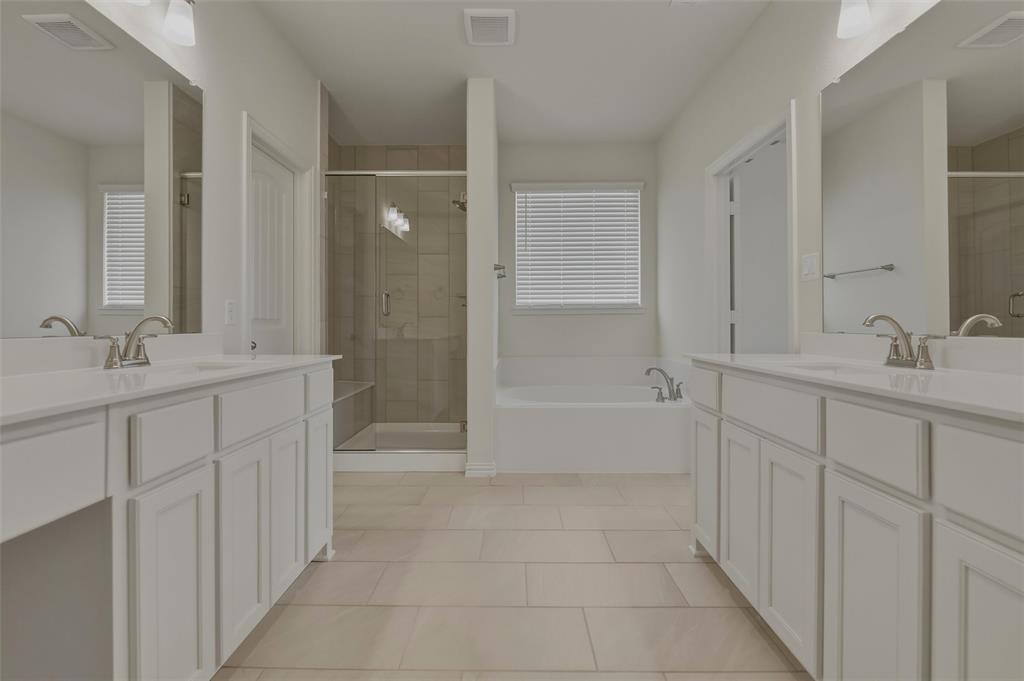 1113 Trinity Drive Springtown, TX 76082 - Photo 29 of 40 Dual vanities with white cabinetry, a glass-enclosed shower, built-in bathtub, and tile flooring