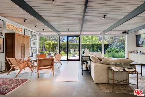 a living room with fireplace furniture and a large window