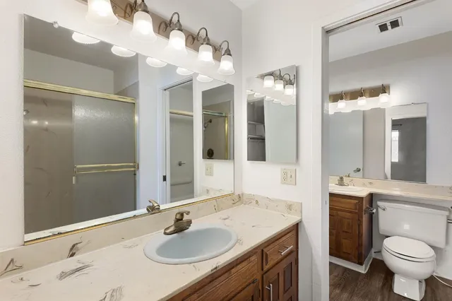 a bathroom with a sink vanity granite and toilet