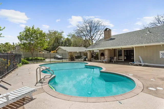 a view of a house with swimming pool and sitting area