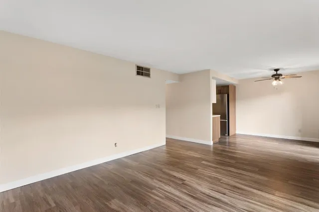a view of an empty room with wooden floor
