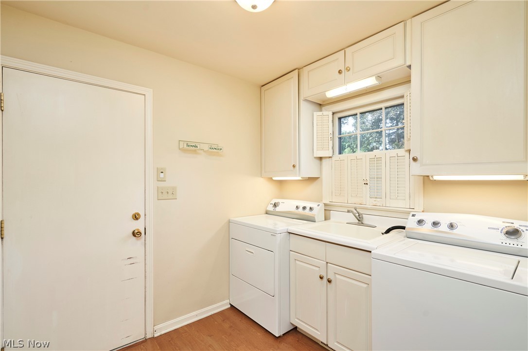 354 Tremont Road Akron, OH 44313 - Photo 18 of 34 Laundry area featuring wood-finish flooring, white cabinetry, integrated sink, and an exterior door
