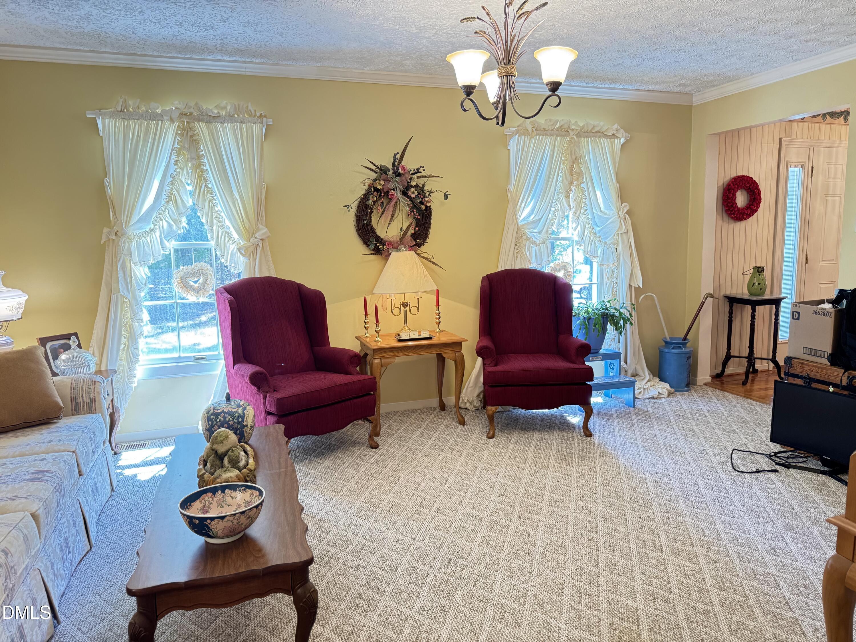 84 Wintergreen Road Henderson, NC 27537 - Photo 16 of 49 a living room with furniture chandelier and a window