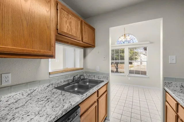 a kitchen with granite countertop a sink stove and cabinets