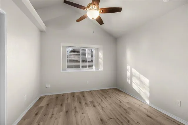 an empty room with a window and wooden floor