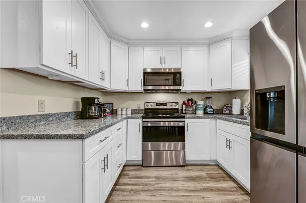 a kitchen with stainless steel appliances granite countertop a stove a sink and a refrigerator
