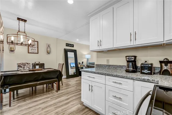 a kitchen with granite countertop a sink cabinets and wooden floor