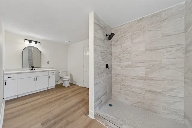 a bathroom with a double vanity sink a mirror and shower