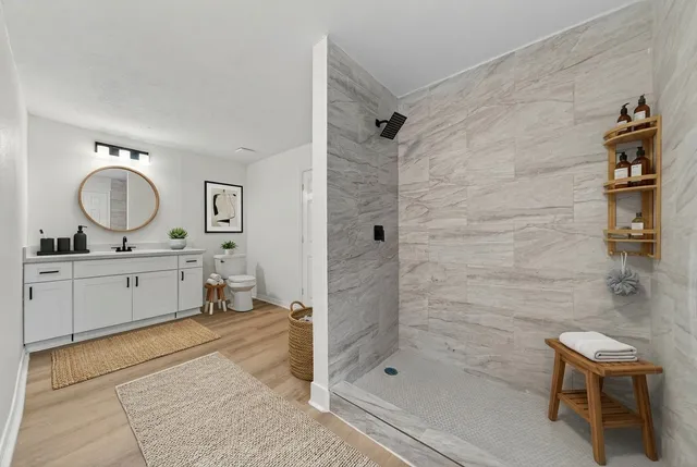 a bathroom with a double vanity sink toilet mirror and shower