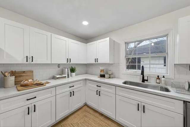 a kitchen with a sink cabinets and window