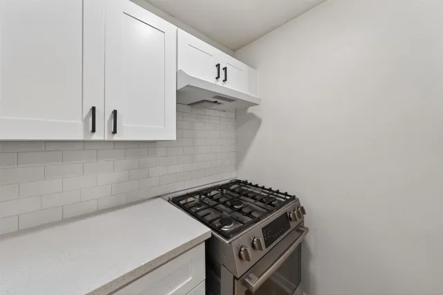 a kitchen with a stove and a white cabinet