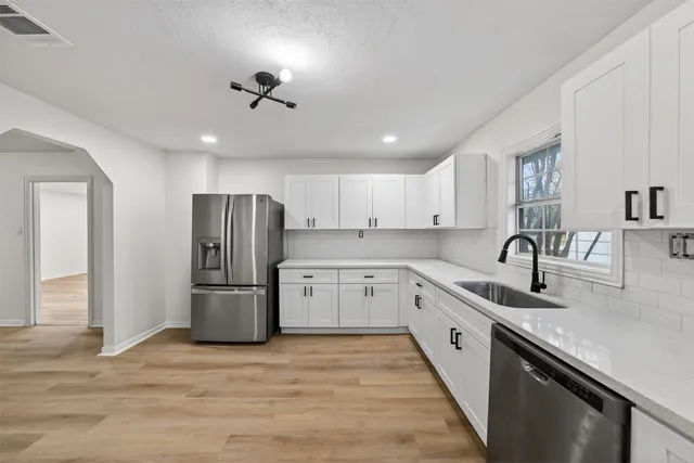 a kitchen with a refrigerator sink and cabinets