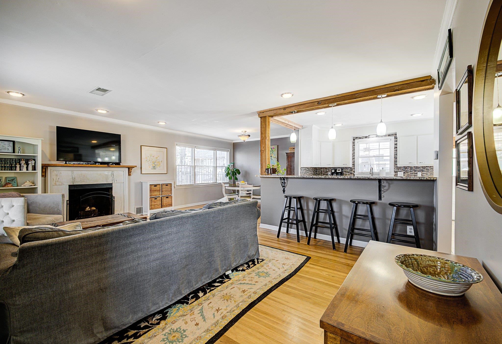 Living room with a tile fireplace, crown molding, and light hardwood / wood-style flooring