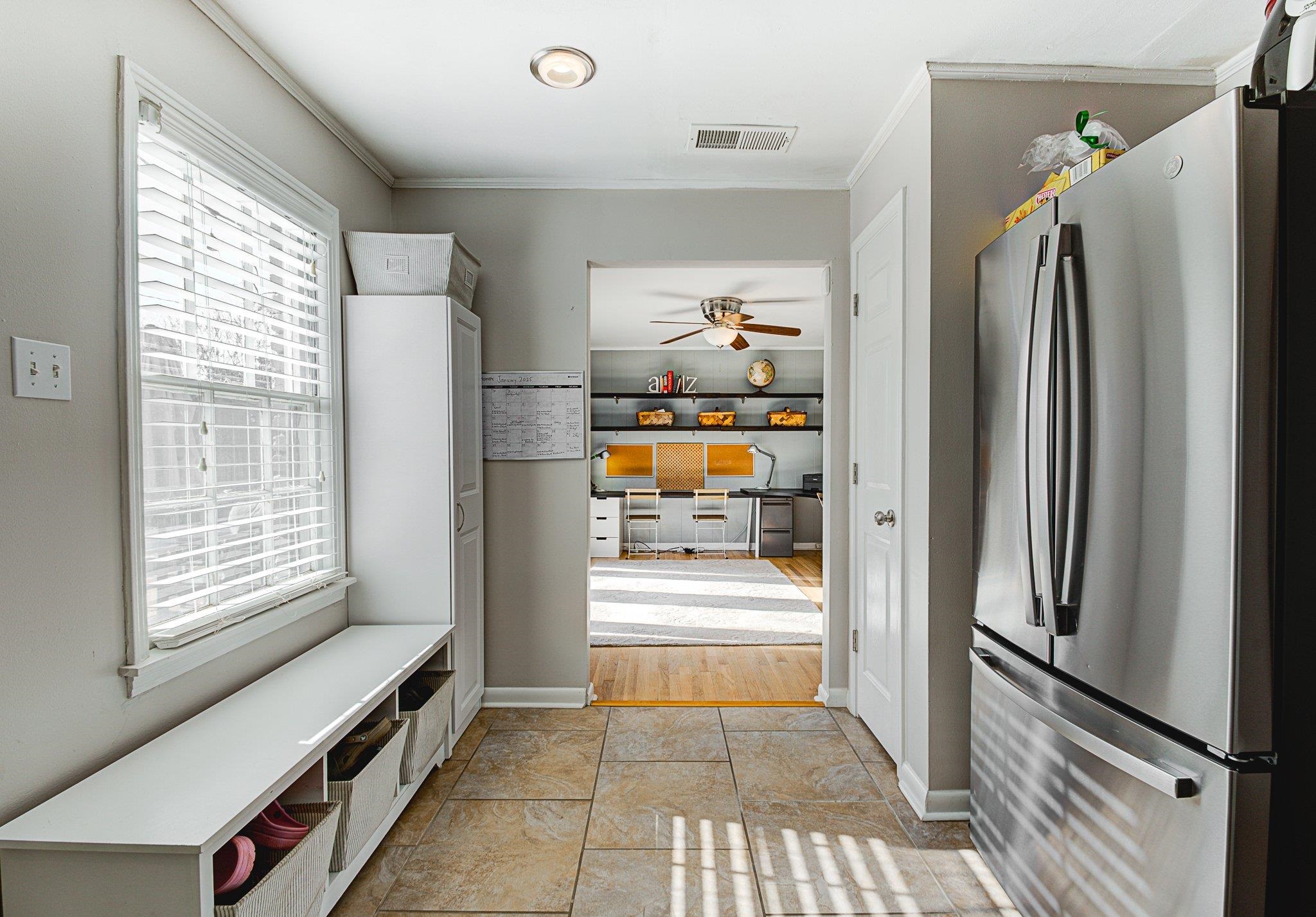 5661 Barfield Road Memphis, TN 38120 - Photo 12 of 31 Kitchen with light tile patterned floors, ceiling fan, stainless steel fridge, and crown molding