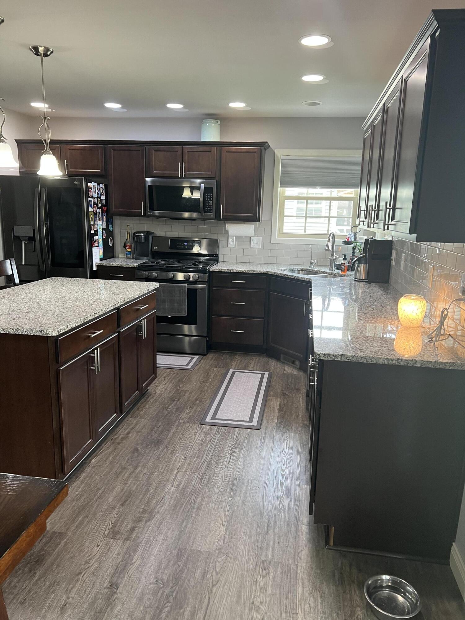702 19th Street Southeast De Motte, IN 46310 - Photo 12 of 22 a large kitchen with stainless steel appliances granite countertop a large counter top a stove a sink a refrigerator and a microwave