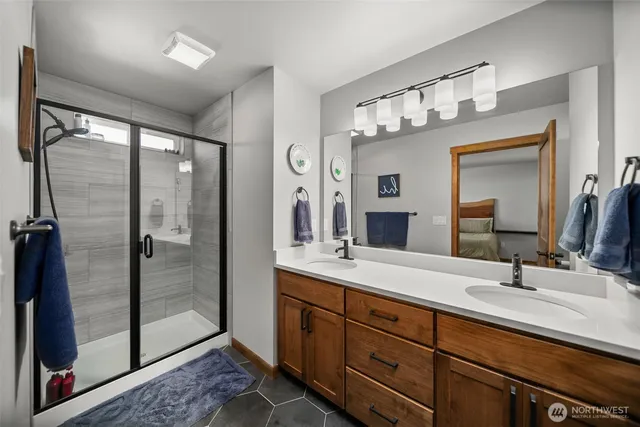 a bathroom with double vanity and a mirror