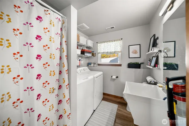 a room with a washing machine and a shower curtain