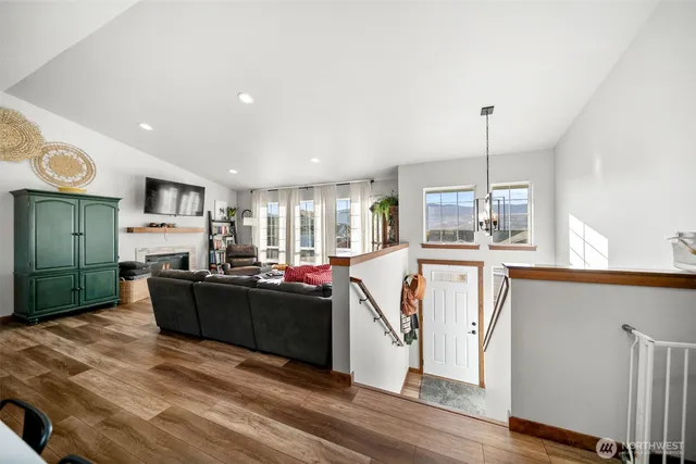 a view of a kitchen with kitchen island granite countertop a refrigerator stove top oven and cabinets