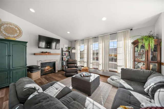 a living room with furniture a fireplace and a flat screen tv