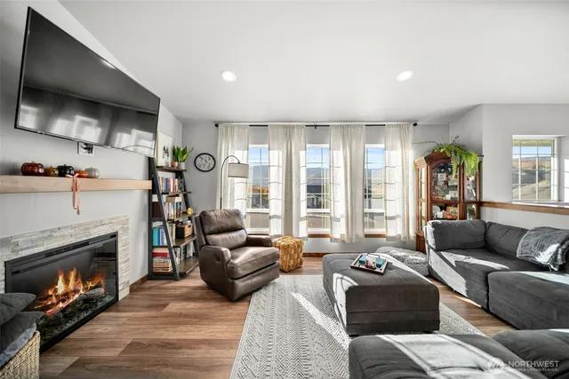 a living room with furniture a flat screen tv and a fireplace