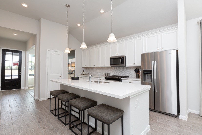 2039 Frst Strm Way Conroe, TX 77304 - Photo 3 of 8 a kitchen with a refrigerator a stove a sink and chairs