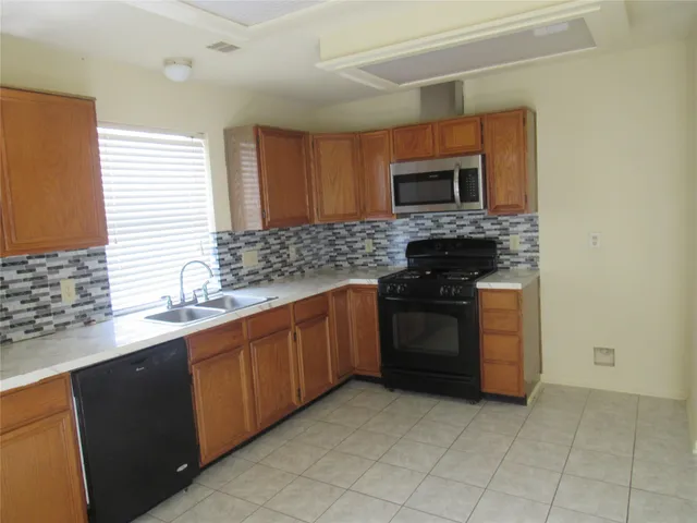 a kitchen with stainless steel appliances granite countertop a stove a sink and a microwave