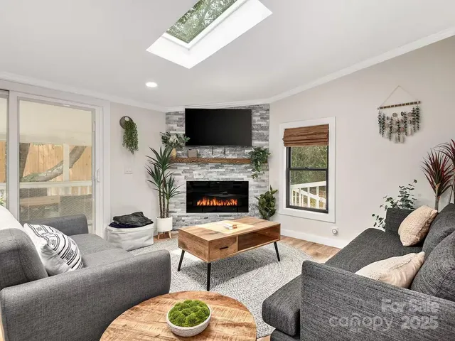 a living room with furniture a flat screen tv and a fireplace