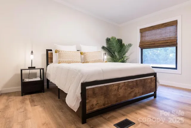 a large bed sitting in a bedroom next to a window