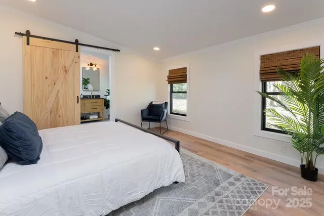 a spacious bedroom with a bed and a potted plant
